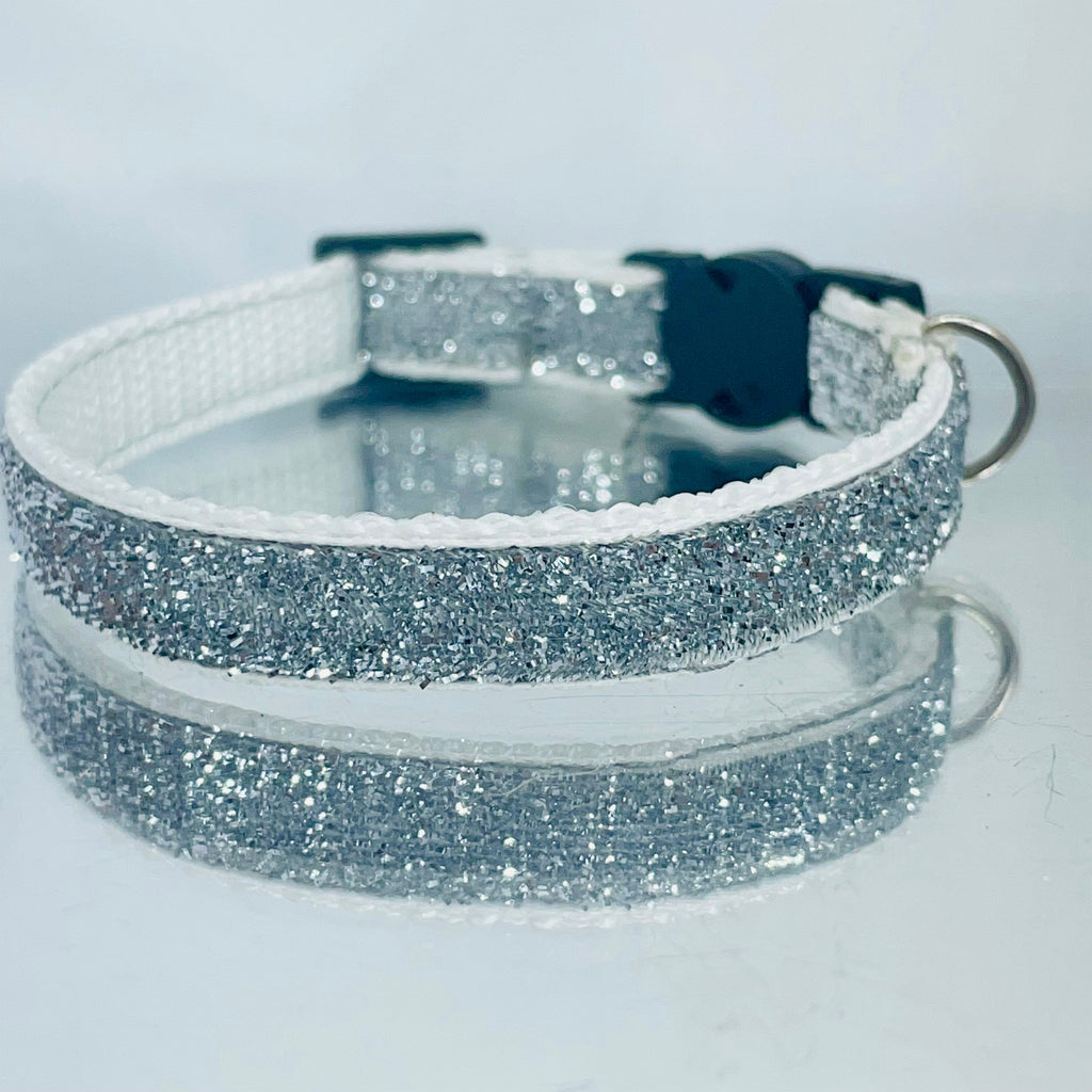 Silver glittery cat collar on a light gray background