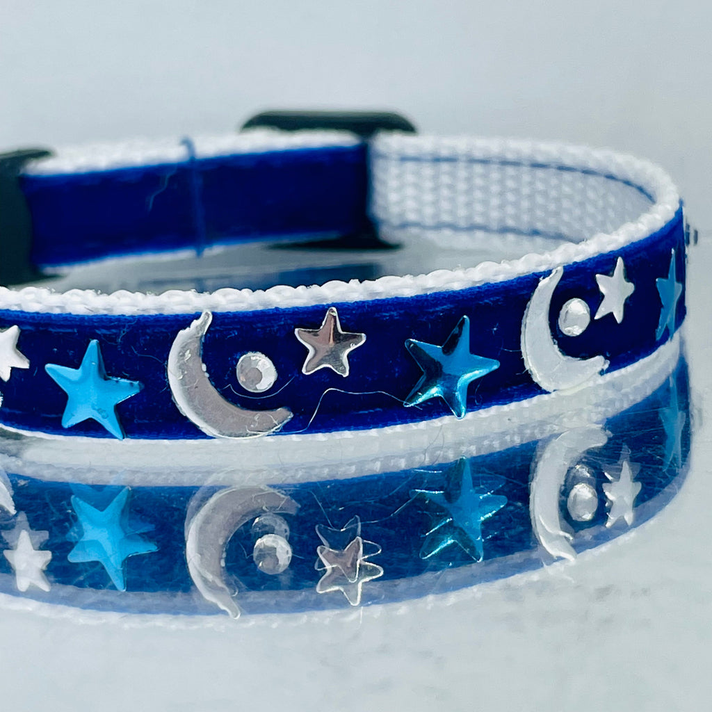 Blue pet collar with star and moon patterns on a light gray background