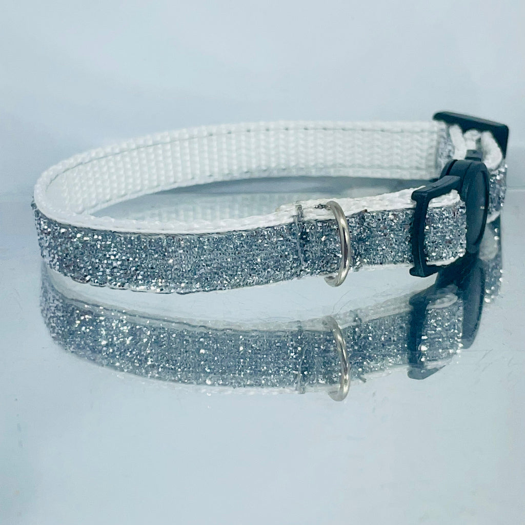 Silver glitter collar with a black buckle on a light gray background