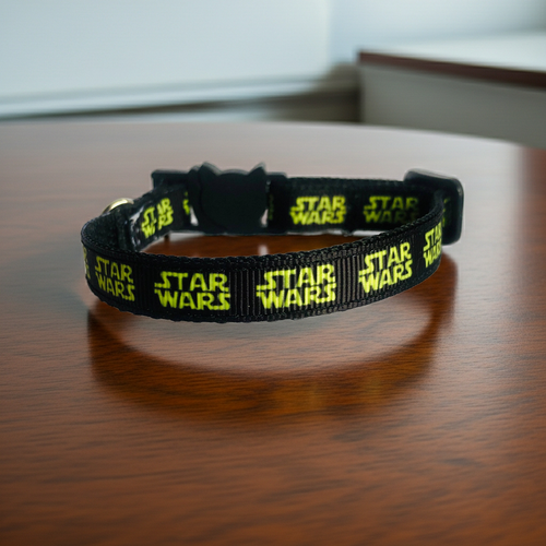 Black 'Star Wars' branded cat collar on a wooden surface