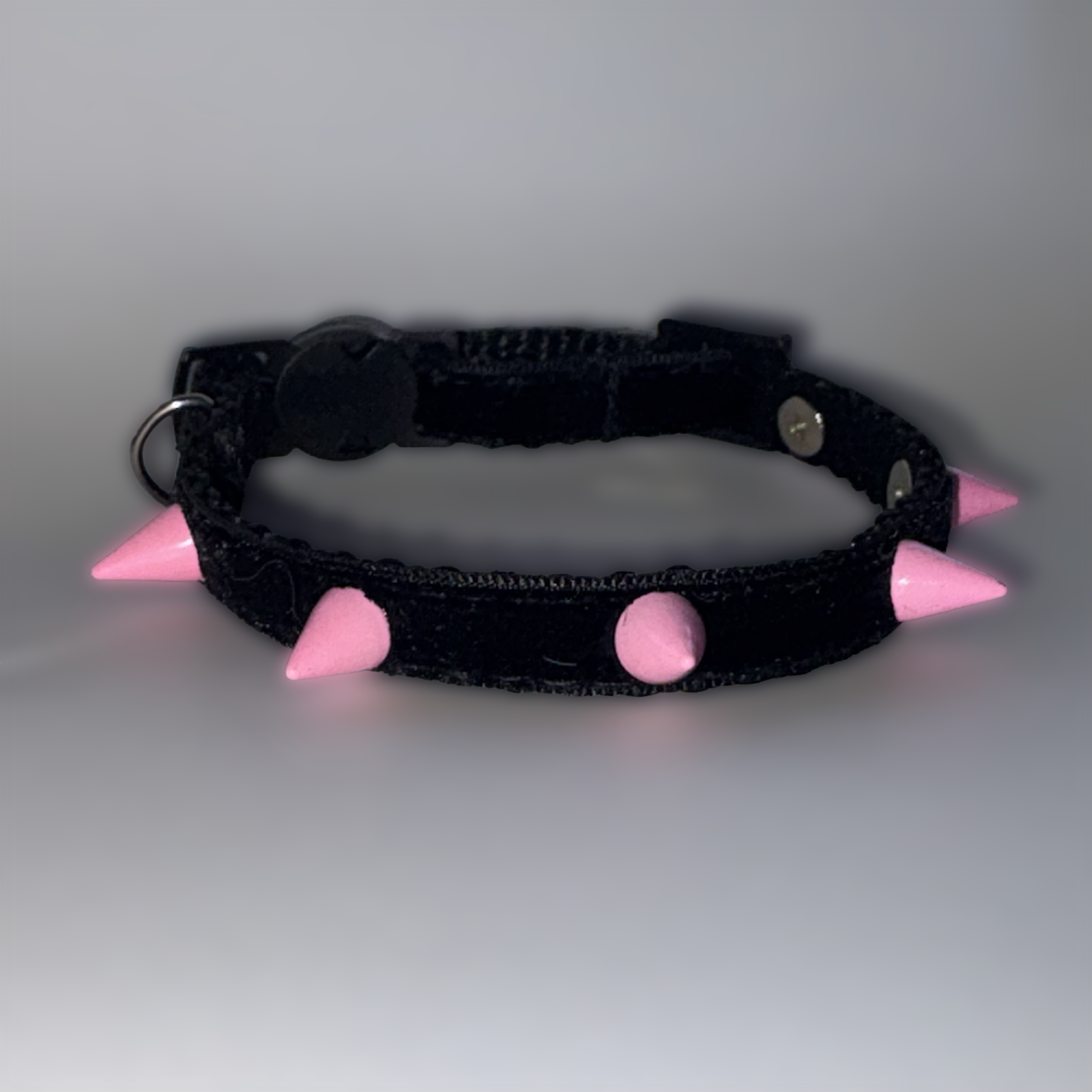 Black collar with pink spikes on a gray background