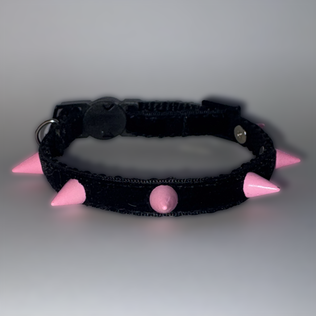 Black collar with pink spikes and a central pink ball on a gray background