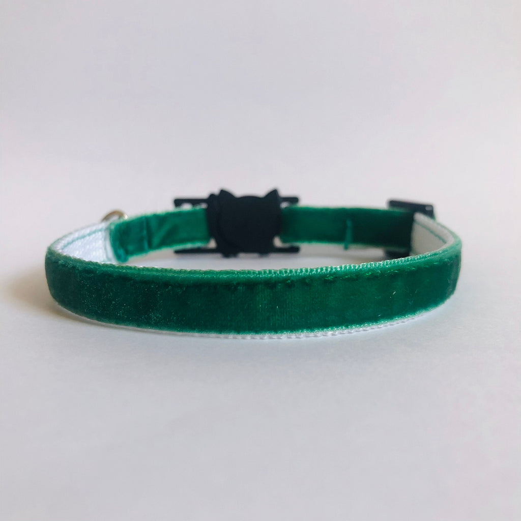 Green velvet collar with a black clasp on a light gray background