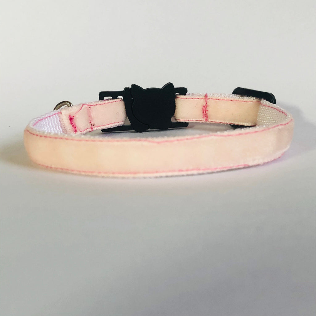 Pink collar with black buckle on a light gray background