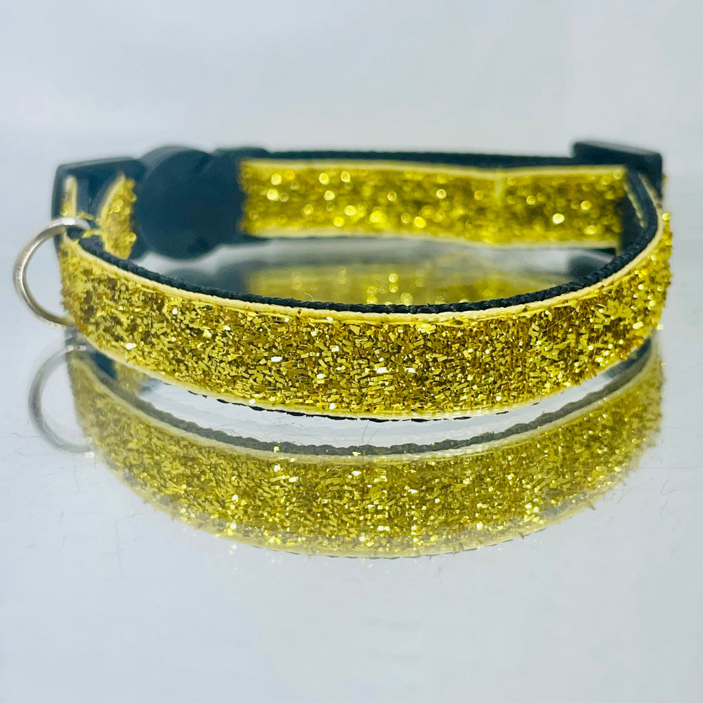 Gold glittery cat collar on a white background