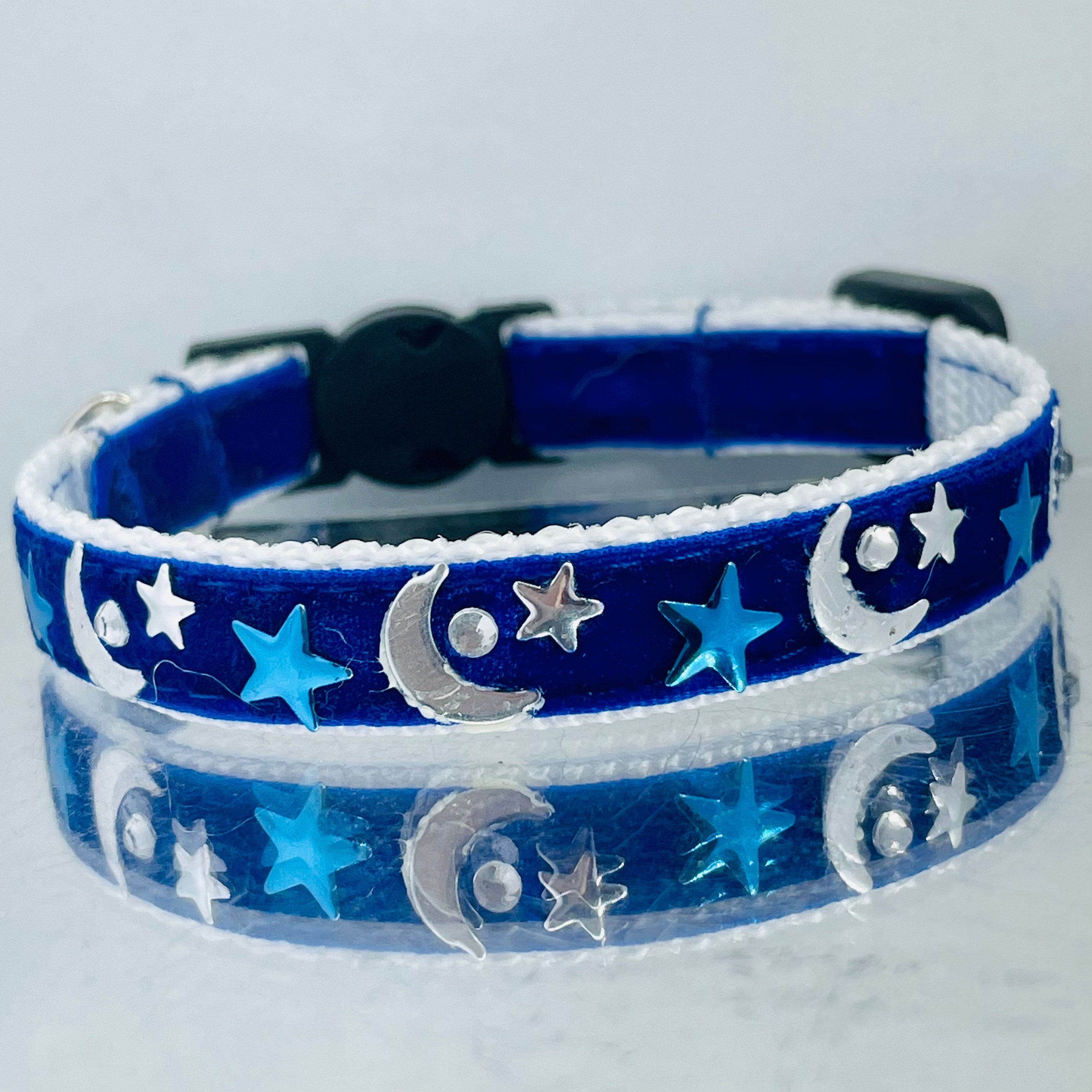Blue pet collar with star and moon patterns on a light gray background